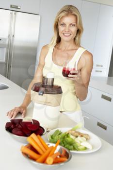 Royalty Free Photo of a Woman Making Vegetable Juice