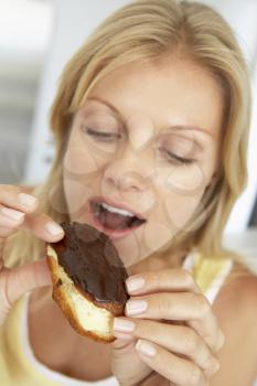 Royalty Free Photo of a Woman Eating a Chocolate Eclair