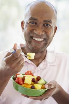 Royalty Free Photo of a Man Eating Fruit Salad