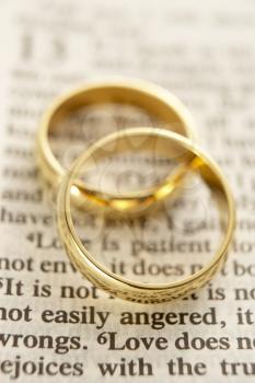 Royalty Free Photo of Two Wedding Rings on the Page of a Bible