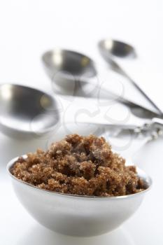 Royalty Free Photo of a Bowl of Brown Sugar With Measuring Spoons