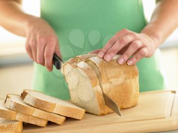 Royalty Free Photo of a Woman Slicing White Bread