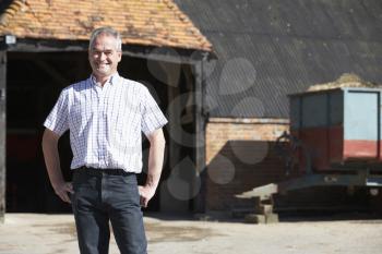 Royalty Free Photo of a Farmer Outside a Building