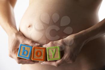 Royalty Free Photo of a Pregnant Woman Holding the Word Boy