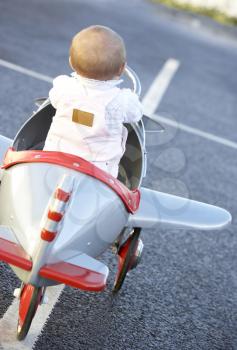 Royalty Free Photo of a Baby Girl Riding a Toy Airplane
