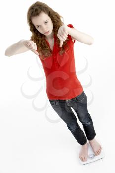 Royalty Free Photo of a Girl Giving Thumbs Down While Standing on Scales