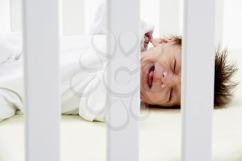 Royalty Free Photo of a Crying Baby in a Crib
