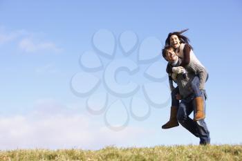 Royalty Free Photo of a Man Giving a Woman a Piggyback