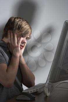 Royalty Free Photo of a Boy Looking Frightened at a Computer