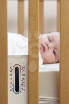 Royalty Free Photo of a Newborn Baby With a Thermometer