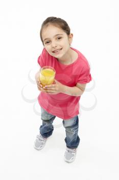Studio Portrait of Smiling Girl Holding Glass of Orange Juice