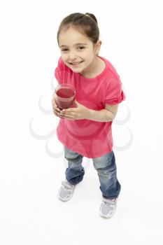 Studio Portrait of Smiling Girl Holding Glass of Juice