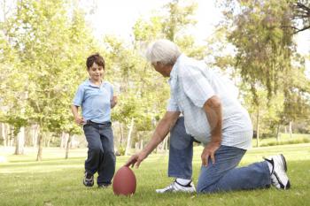 Royalty Free Photo of a Grandfather and Grandson With a Football
