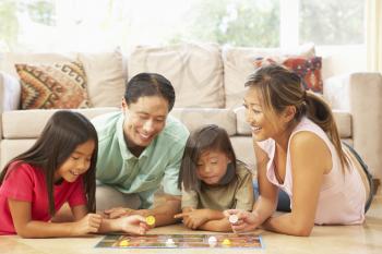 Royalty Free Photo of a Family on the Floor Playing a Game