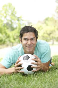 Royalty Free Photo of a Man on the Ground With a Soccer Ball