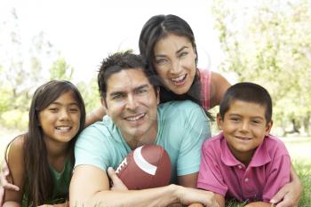 Royalty Free Photo of a Family on the Ground With a Football