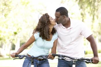 Royalty Free Photo of a Couple on Bikes Kissing