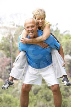 Royalty Free Photo of a Man Giving a Woman a Piggyback Ride