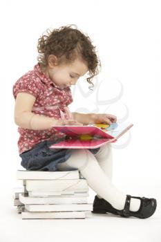 Young Girl Sitting On Pile Of Books Reading