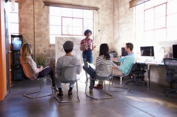 Group Of Designers Having Brainstorming Session In Office