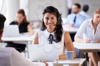 Businesswoman Using Laptop In Customer Service Department