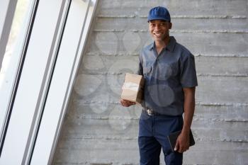 Portrait Of Courier Collecting Package From Office