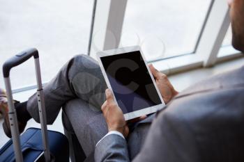 Businessman Using Digital Tablet In Airport Departure Lounge