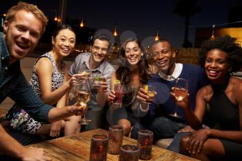 Portrait Of Friends Enjoying Night Out At Rooftop Bar