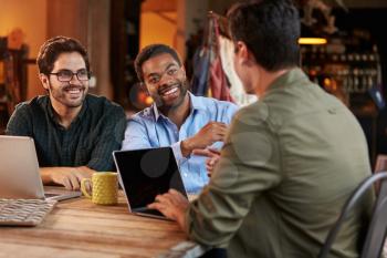 Three Male Fashion Designers In Meeting Using Laptop