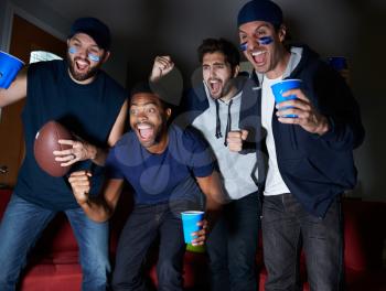Group Of Male Sports Fans Watching Game On Television