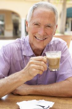 Senior Man Enjoying Coffee And Cake In Caf