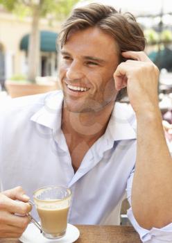 Young Man Enjoying Cup Of Coffee In Caf