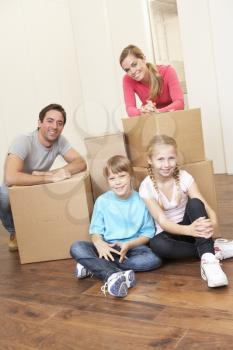 Young family on moving day looking happy among boxes