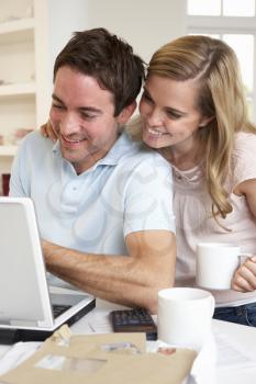 Happy young happy couple looking and reading a laptop computer