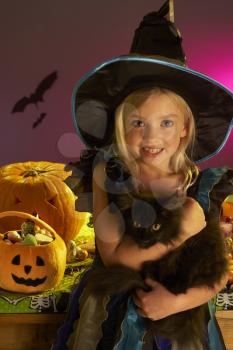 Halloween party with a child holding black cat in hand