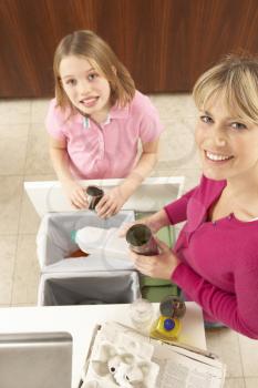 Mother And Daughter Recyling Waste At Home