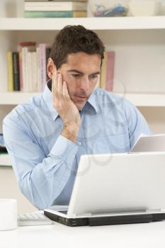 Worried Looking Man Working From Home Using Laptop