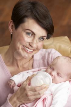 Portrait Of Mother Feeding Newborn Baby At Home