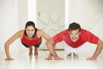 Couple doing push-ups in home gym