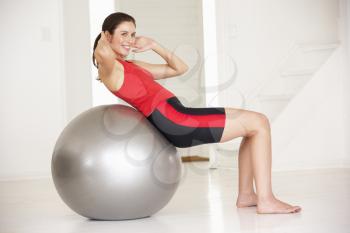 Woman with gym ball in home gym