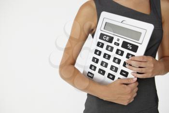 Young businesswoman with giant calculator