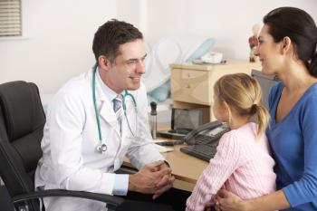 American doctor talking to young child and mother