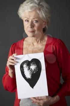 Senior woman holding ink drawing of heart