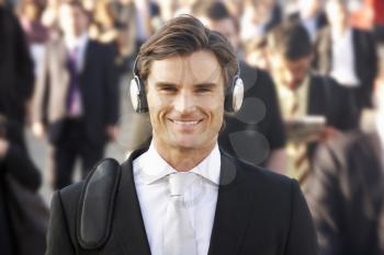 Male commuter in crowd wearing headphones