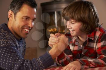 Father And Son Arm Wrestling By Cosy Log Fire