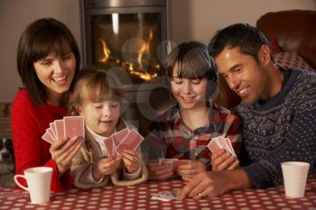 Portrait Of Family Playing Cards By Cosy Log Fire