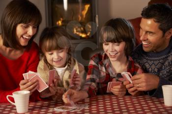 Portrait Of Family Playing Cards By Cosy Log Fire