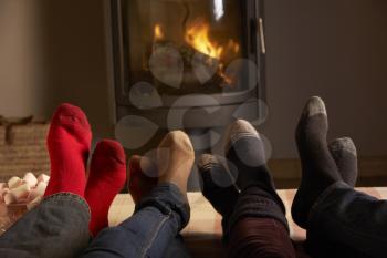 Close Up Of Familys Feet Relaxing By Cosy Log Fire With Marshmallows