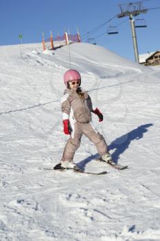 Young Girl Skiing Down Slope Whilst On Holiday In Mountains