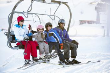 Family Getting Off chair Lift On Ski Holiday In Mountains
